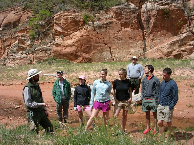 Growing visitation means increased strain on park resources—education is key to preserving Cedar Breaks. Ranger leads a group near cliffs at Cedar Breaks during a visitor engagement session