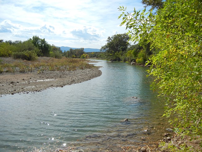 A creek winding through the landscape on a sunny day