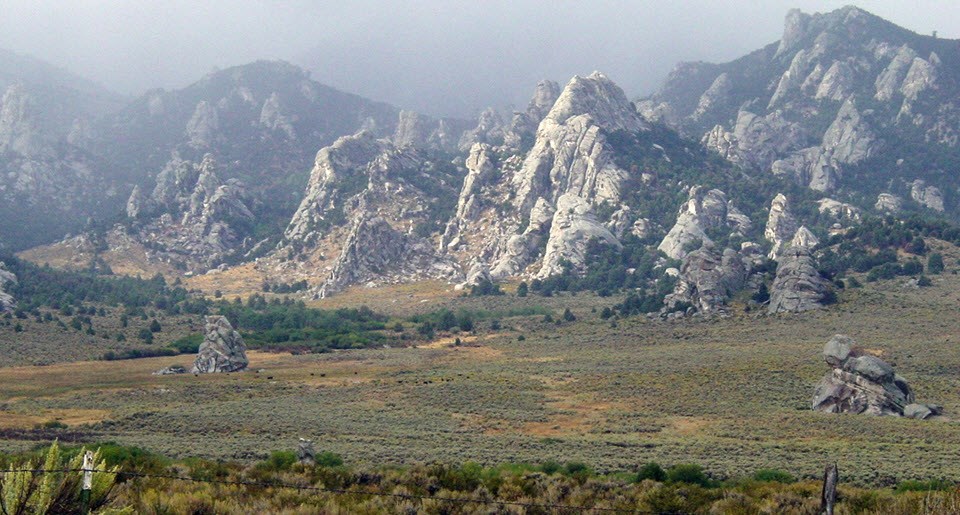 Sagebrush in the foreground and rocky outcrops in the distance