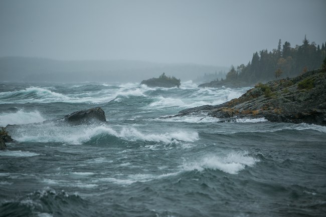 Waves crash on a rocky shoreline.