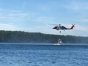 A swimmer being rescued from an NPS vessel by a USCG helicopter.