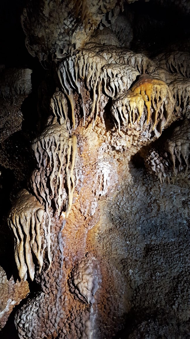 Light brown flowstone over bumpy crystal