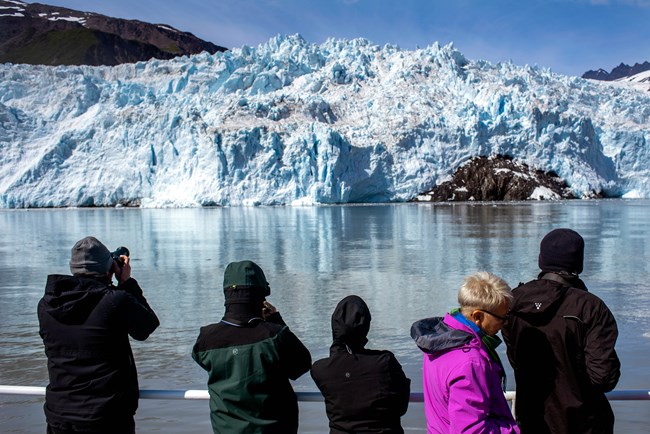 People view large tidewater glacier from boat