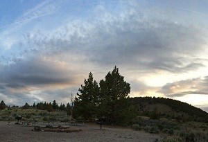 Group campsite and surroundings, including picnic tables, grills, and jumper trees