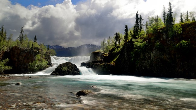 waterfall and river surrounded by rocks and trees