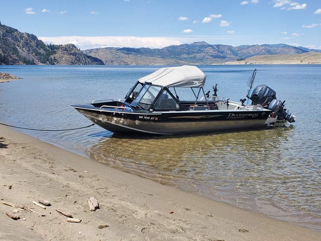 a small motorboat is tied to the shoreline