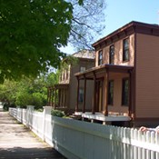 2 story reddish-tan house with small porch