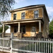 2 story yellow house with white trim and a front porch