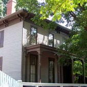 2 story gray and dark red home with small porch