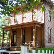 2 story pink and tan house with a porch