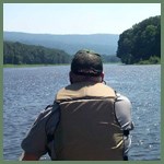 Ranger canoeing with mountains inthe distance