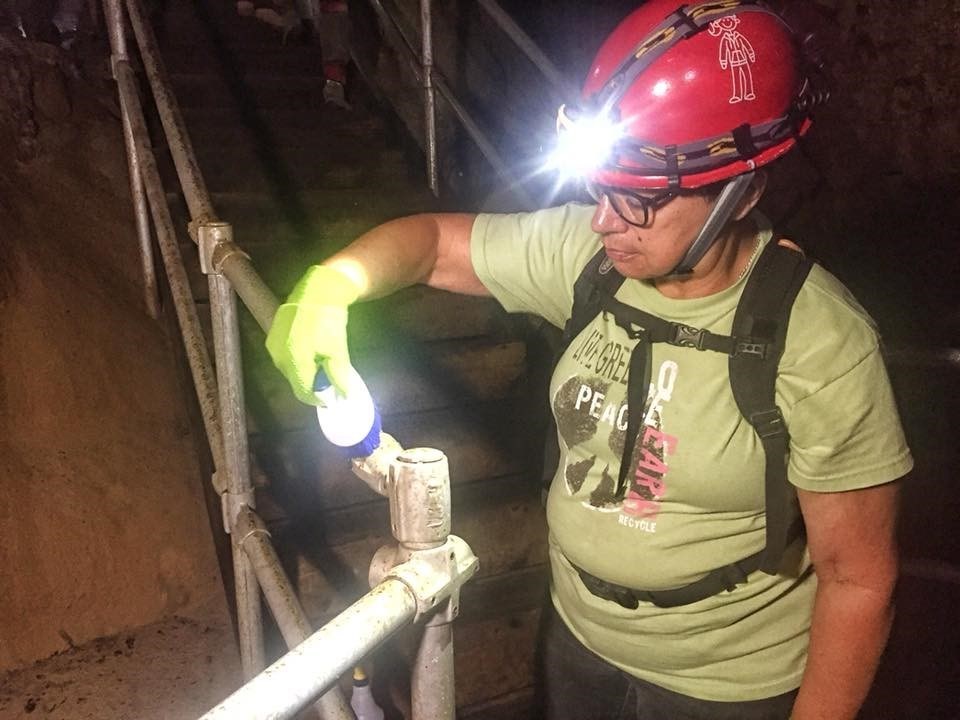 A volunteers cleans a handrail with a brush