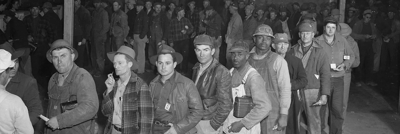 A long line of men in work outfits.