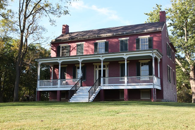 A two-story red brick house with a wide front porch.