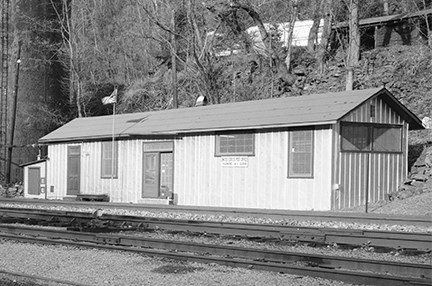 A long single story building with a sign that says United States Post Office Thurmond sitting next to railroad tracks