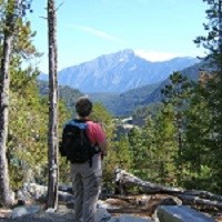 A person stands looking at a mountain view.