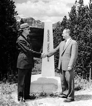 NPS and Canadian park superintendents shaking hands across the border.