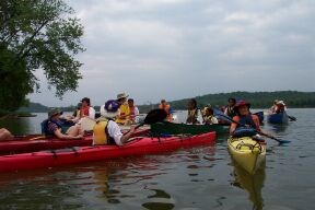 group of paddlers in kayaks along shoreline