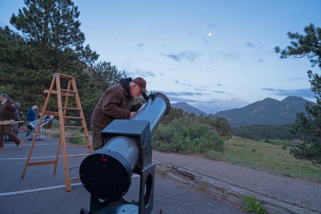 NPS volunteer is setting up a telescope