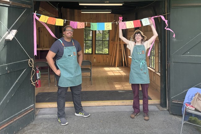 two artists standing in front of workshop