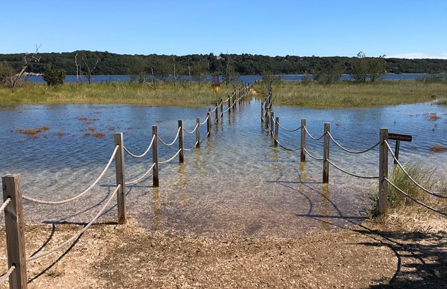 A flooded path leading to a beach.