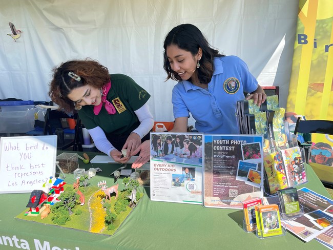 Two interns stand together, demonstrating a tabling activity.