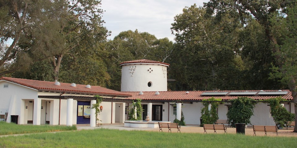 A single storied and light colored building with red tiles