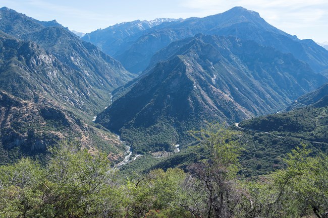 A river cuts through a deep canyon surrounded by granite mountains.