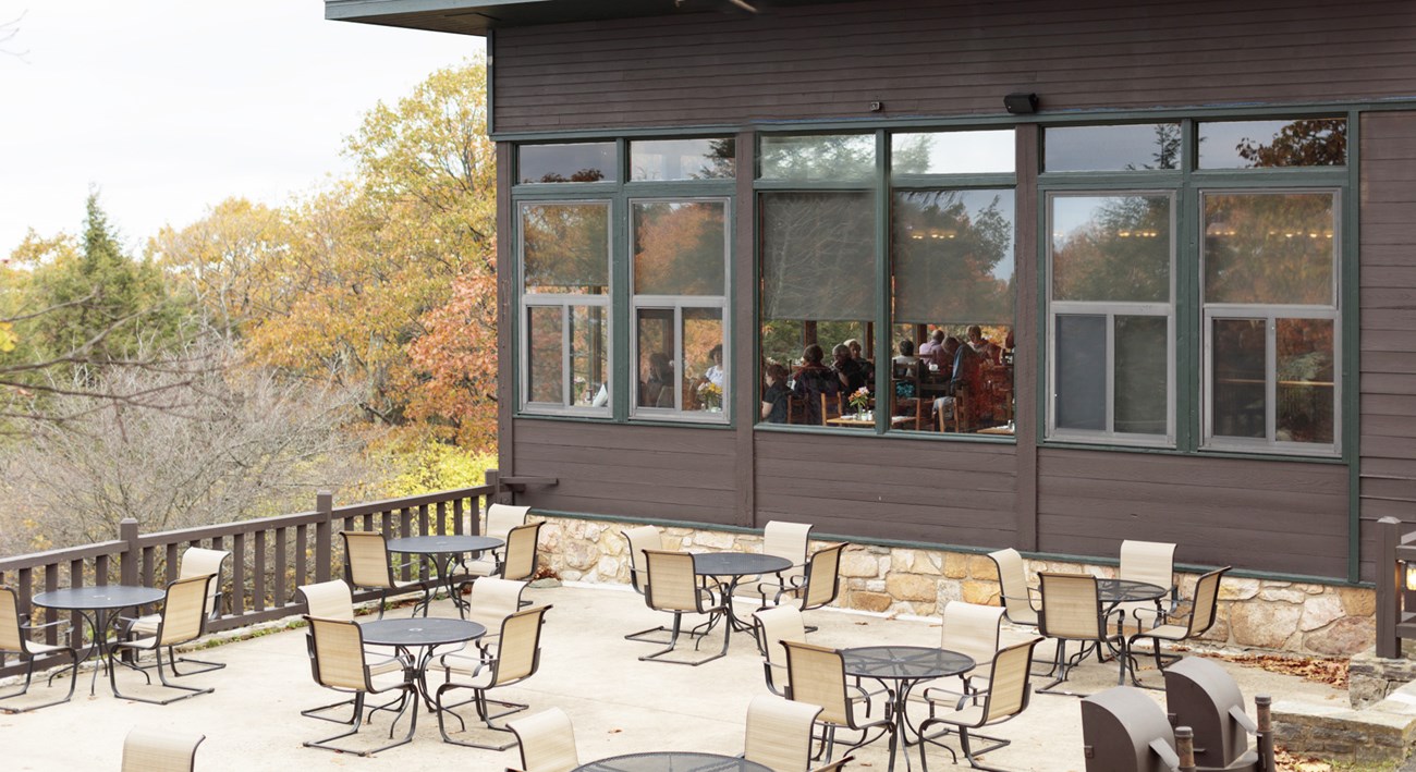 A patio full of tables outside of a restaurant.