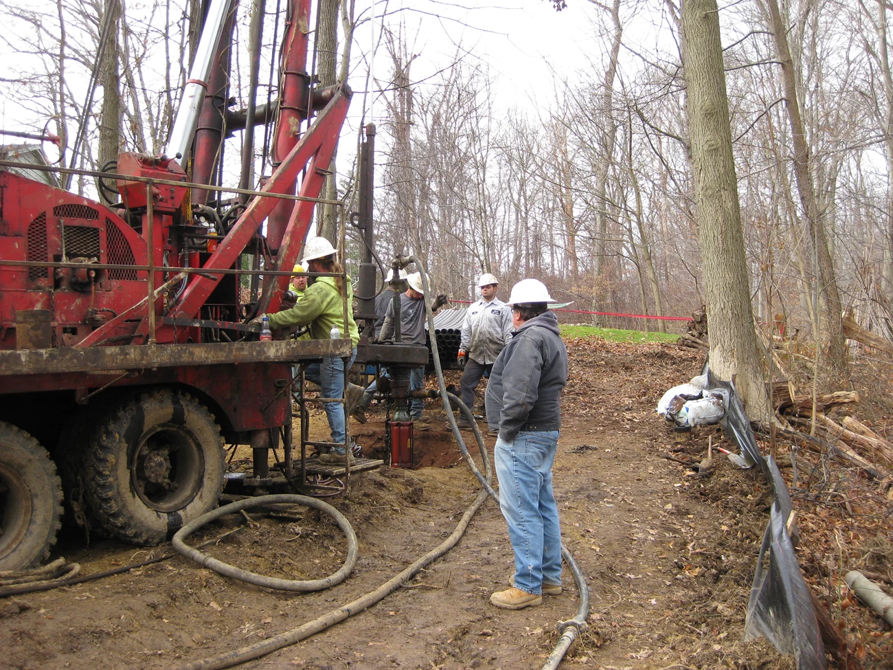 closing abandoned oil and gas wells men with heavy equipment working in the woods