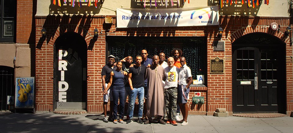 a diverse group of people gathered in front of the Stonewall Inn