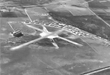 Two landing strips criss-crossing with buildings behind them