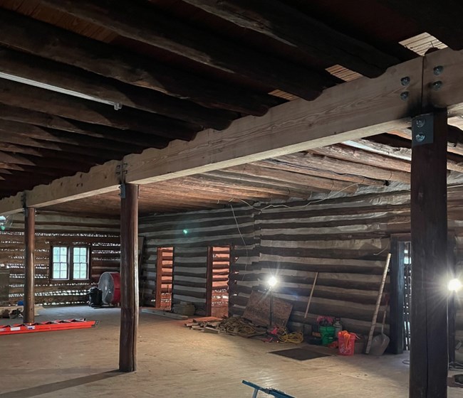 Interior old log cabin with construction materials lying around.