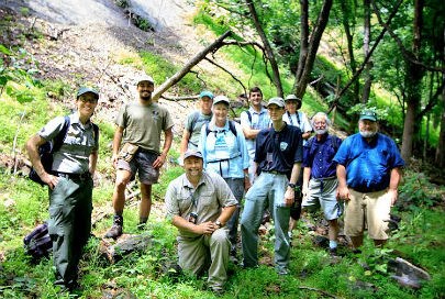 group of people gathered together in wooded area