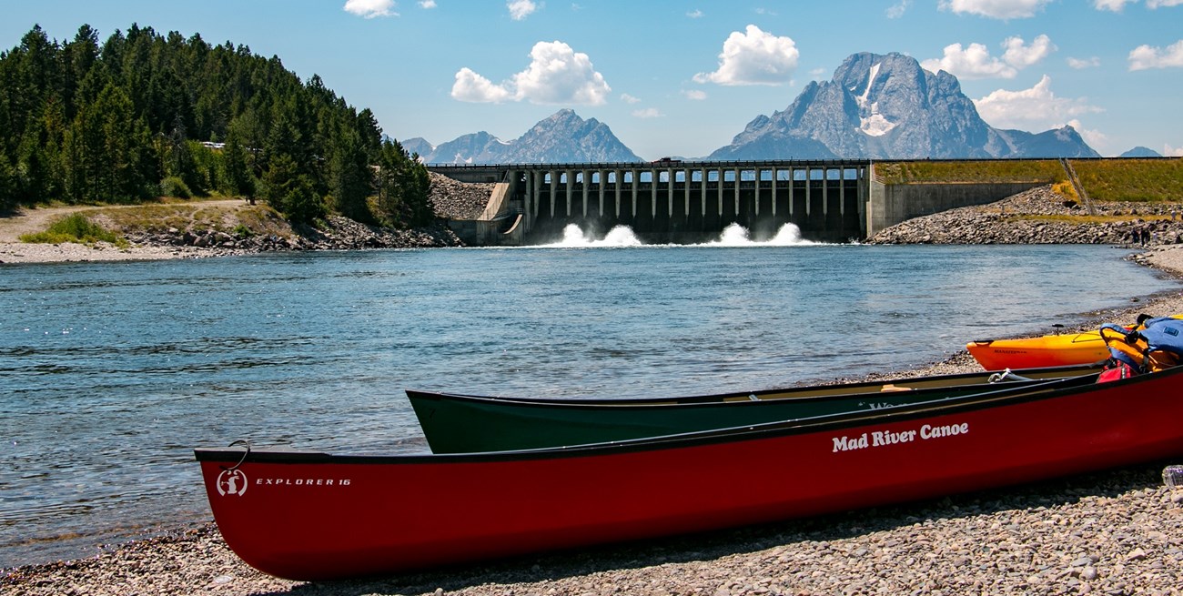 Canoes and gear parked on shore near lake