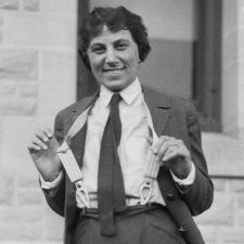 Smiling woman in uniform pulls on her suspenders