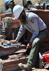 NPS employee making repairs to a historic masonry wall.