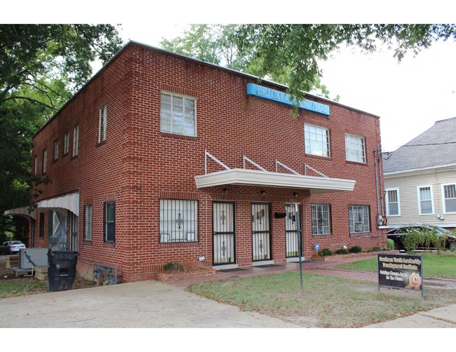 two-story brick building with blue sign on brick: Bricklayers Hall