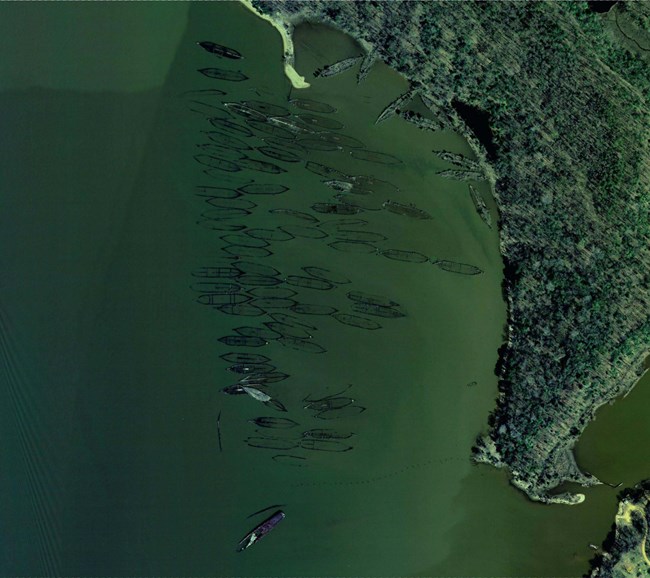 Aerial view of the shapes of ships sunken under water in a bay