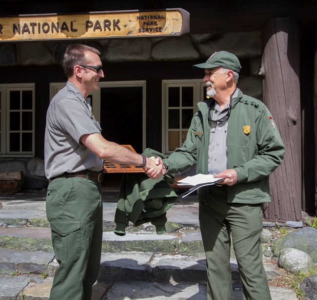 Rangers shaking hands and exchanging an award