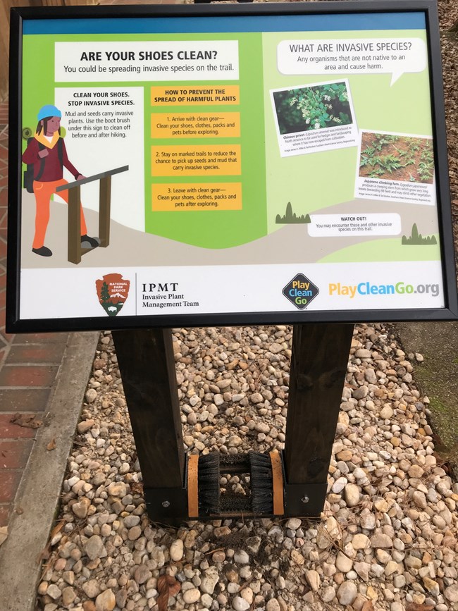 A boot brushing station with sign describing how to prevent the spread of harmful plants