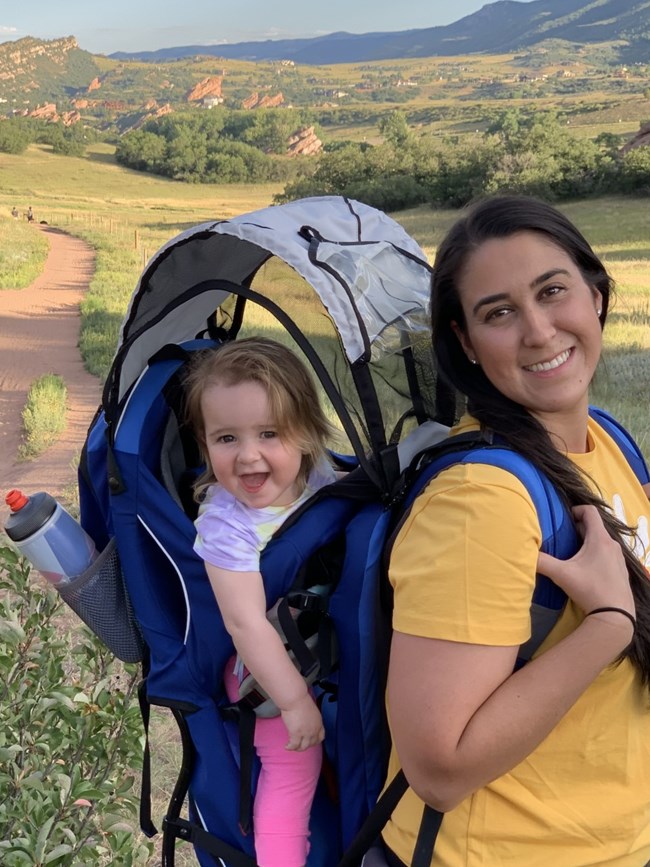 a mom carries her child in a child carrier backpack