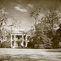 two-story house featuring front columns and a widow;s walk on top