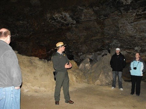 Ranger talking to three people on rock platform