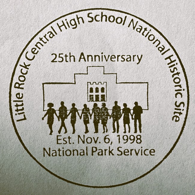 CHSC 25th passport stamp Junior ranger badge reads, "Central High School National Historic Site 25th anniversary 2023" and shows the sihouettes of nine figures walking in front of the main facade at Central High.