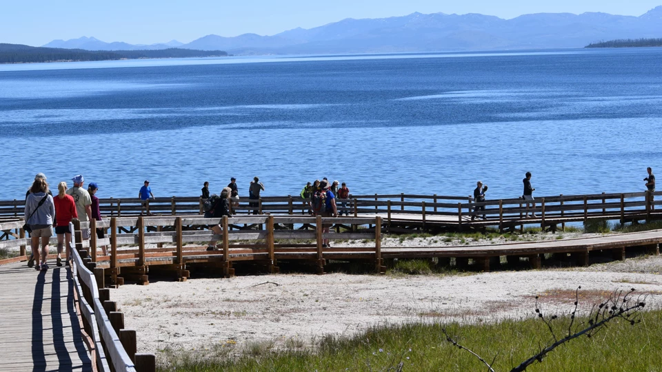 People walking along West Thumb Geyser Basin boardwalk People walking along West Thumb Geyser Basin boardwalk