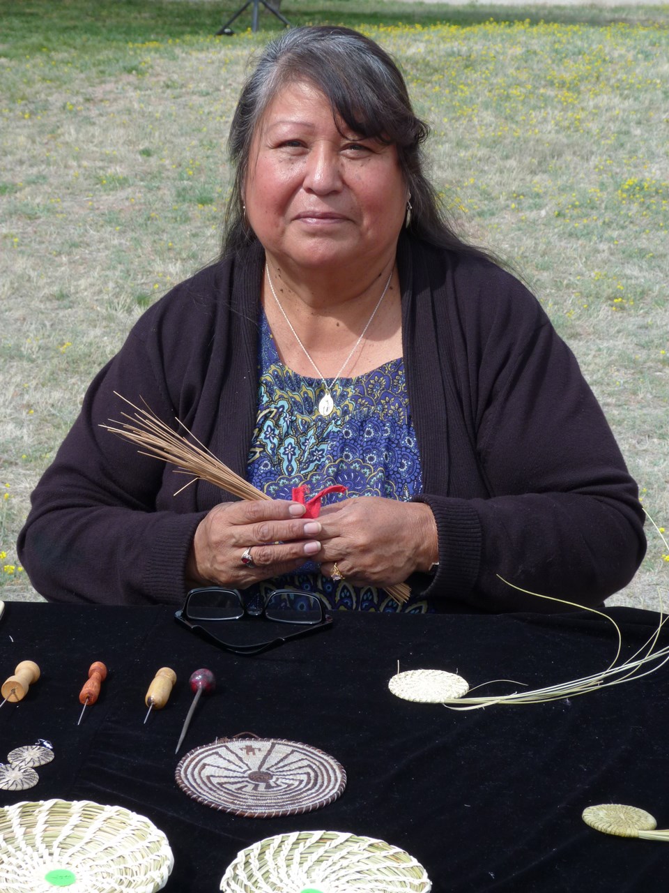 Demonstrator holding basketry materials.