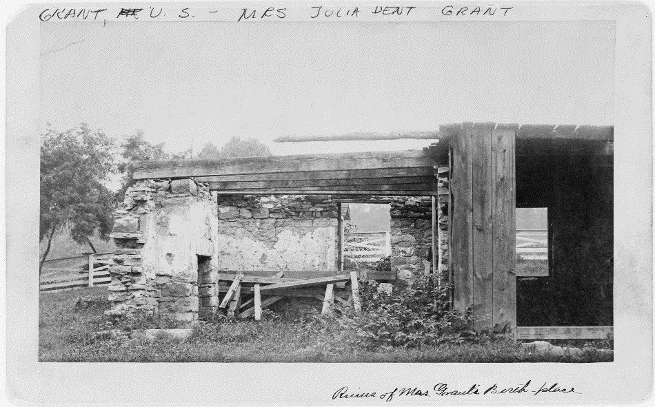 Black and white photo of a partially collapsed stone building with two rooms