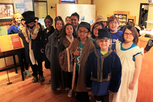 students standing in a museum and smiling at camera.