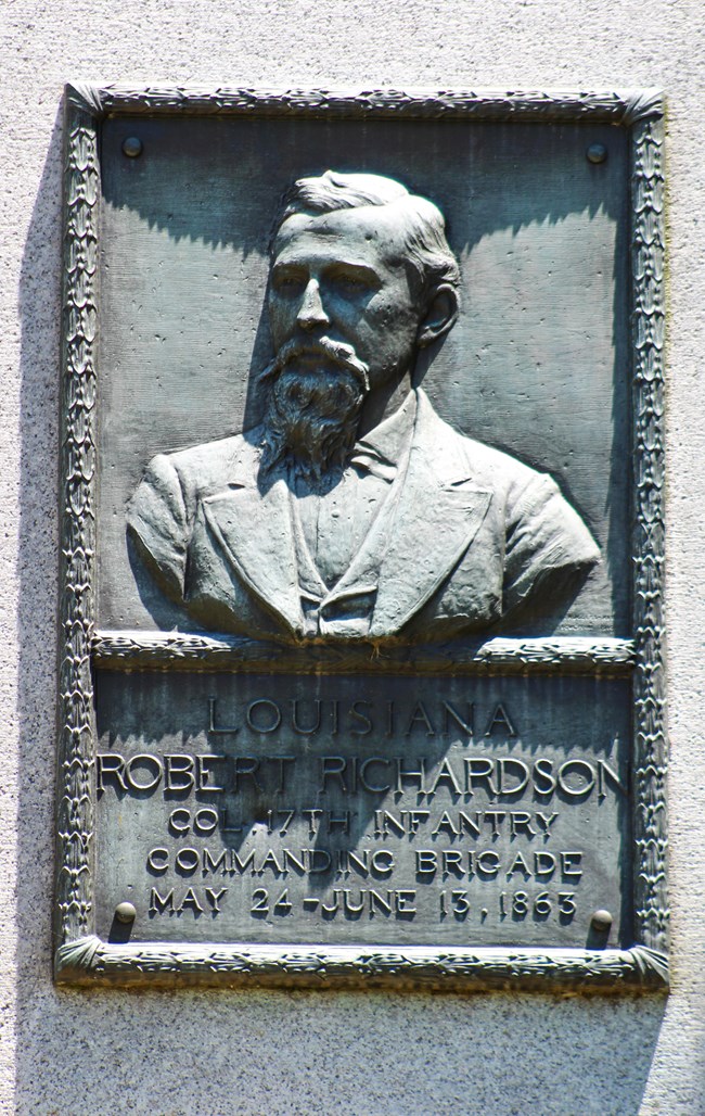 A bronze relief portrait of a man in a uniform